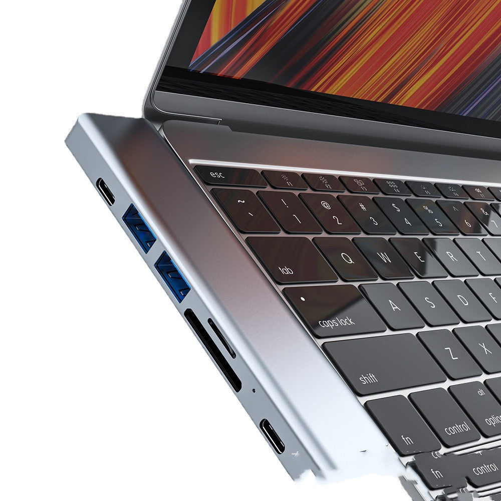 Silver aluminum alloy laptop converter expansion dock with multiple ports for data interface.
